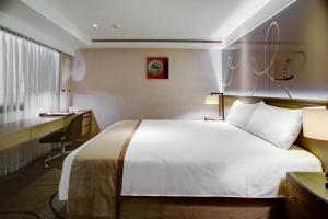 高雄翰品酒店高雄的配有一张床和一张书桌的酒店客房