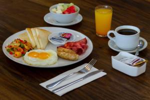 库塔PrimeBiz Hotel Kuta的包括鸡蛋、烤面包和咖啡的早餐盘