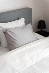 扎芬特姆Studio Brussels - Central的一张带白色床单和枕头的床以及一盏灯