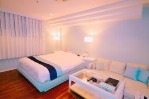 那须町Hotel Aqua Vitae (Adult Only)的一间卧室配有一张床和一张沙发