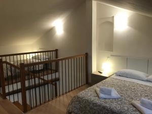 费拉拉APPARTAMENTI del DUCA的一间卧室设有一张床,楼梯设有楼梯。