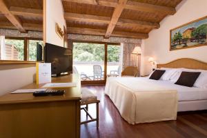 加尔达加尔达博亚诺度假酒店的酒店客房配有一张床和一张带电脑的书桌