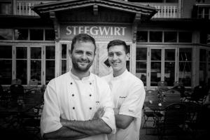 巴德哥依斯恩Welterbe-Wirtshaus Steegwirt的两名厨师站在餐厅前