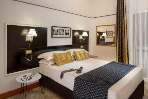 罗马Amalia Suites by Remember Rome的配有一张大床和镜子的酒店客房