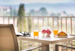 波尔托罗Remisens CASA ROSA - Hotel Metropol Annexe的一张桌子,上面放着两杯,还有一盘食物和橙汁