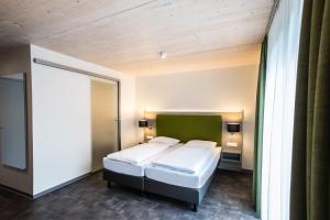 LottstettenHotel Holzscheiter的一间卧室设有两张床和绿色床头板