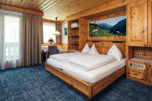 萨姆瑙恩恩加丁疗养酒店的木制客房内的一间卧室配有一张大床