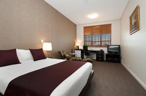 阿德莱德阿达科精品酒店的酒店客房设有一张大床和一张书桌。