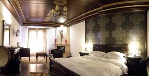 卡兰巴卡Guesthouse Iridanos的一间卧室配有一张大床和一个吊灯。