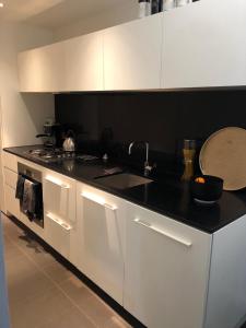 墨尔本Fantastic Southbank Apartment的厨房配有白色橱柜、水槽和炉灶。