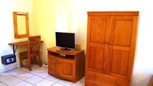 索德瓦纳湾Reefteach Lodge的一间配有电视和木制橱柜的客房