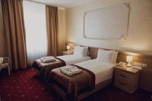 文尼察法兰西酒店的酒店客房设有两张床和窗户。