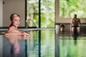 新波南特格尼斯可杰霍夫山温泉度假酒店的躺在游泳池中的女人