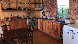 特雷热比奇欢迎瓦布斯旅馆的厨房配有木制橱柜和桌子。