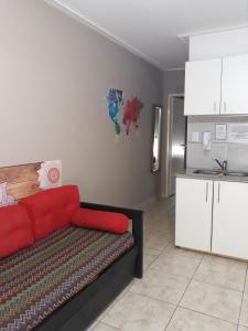 布兰卡港Departamento Viamonte con cochera的一间带红色沙发的客厅和一间厨房