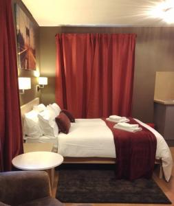 考文垂Bede Apartments的酒店客房,配有床和红色窗帘