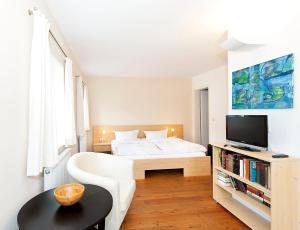 巴特尚道Fährmannhaus的一间白色卧室,配有床和电视