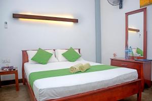 卡图纳耶克迪隆旅馆的一间卧室配有一张床,上面有两条毛巾