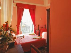 陶尔米纳Villa Mabel的红色卧室设有两张床和窗户