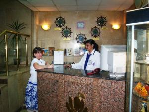 阿斯旺兰花圣乔治酒店的两名妇女在餐厅柜台站立