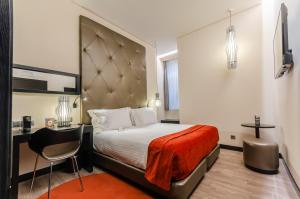 里斯本圣塔胡斯塔酒店的配有一张床和一把椅子的酒店客房