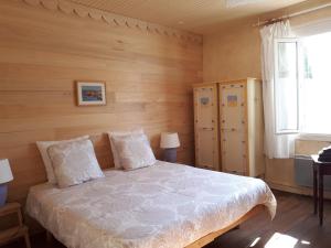 RabastensSûn Chambres d'hôtes的一间卧室配有一张带木墙和窗户的床。