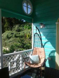卡斯特里棕榈小屋的门廊上的摇椅,带窗户