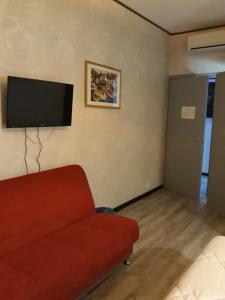 米兰Sira House Milano的客厅配有红色沙发和平面电视