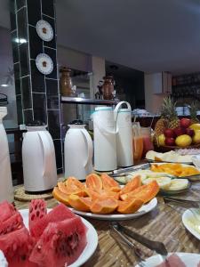 马塞约Pousada Terra Garrida的一张桌子,上面放有水果盘和牛奶罐