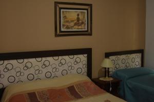科隆Apartamento Los Abuelos Calle Esteva Berga的卧室配有一张床,墙上挂着一幅画