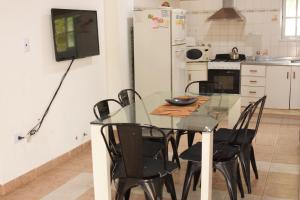 科隆Apartamento Los Abuelos Calle Esteva Berga的厨房配有玻璃桌和黑色椅子