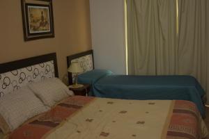 科隆Apartamento Los Abuelos Calle Esteva Berga的酒店客房设有两张床和窗户。
