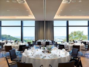 瓦尔登堡Panoramahotel Waldenburg的用餐室设有桌椅和窗户。