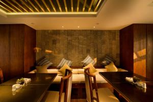 杭州杭州野风君亭酒店的一间带桌椅和沙发的用餐室