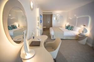 阿尔宗Miramar La Cigale Hotel Thalasso & Spa的酒店客房,设有两张床和镜子