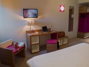 卡斯特尔卡斯特尔宜必思尚品酒店的客房设有一张床、一张桌子和一台笔记本电脑