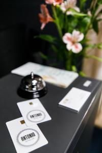 乌日霍罗德Hotel Antonio的一张带卡片的黑色桌子和花瓶