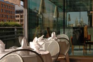 布达佩斯Crowne Plaza Budapest, an IHG Hotel的一排桌子和椅子上都装有白色的餐巾