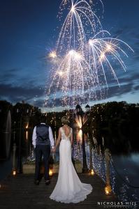格雷夫森德湖上旅馆的站在烟花展示下的一名新娘和新郎