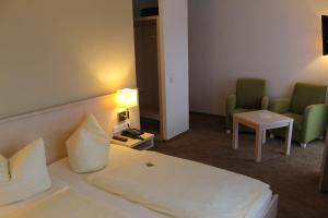 Hemfurth-Edersee多恩罗森索瓦尔德霍特尔酒店的酒店客房配有一张床、两把椅子和一张桌子