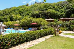 巴拉多库努Pousada do Forte的一个带游泳池和树木的度假庭院
