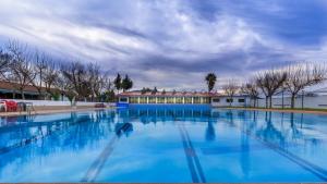 Mollina莫利诺萨多酒店的一座蓝色的大型游泳池,其建筑背景为: