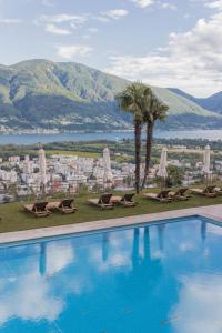 洛迦诺Villa Orselina - Small Luxury Hotel的一个带椅子的游泳池,享有城市美景