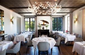 尚博尔查博德世界小型豪华酒店的餐厅配有白色的桌椅和吊灯