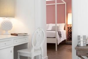 莱切曼塔特鲁尔酒店的卧室配有白色椅子和带镜子的书桌