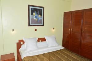 杜阿拉Hotel - Y的卧室配有带白色枕头的大床