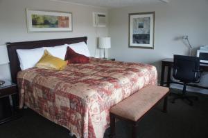 圣阿加瑟莫克莱尔蒙特汽车旅馆的一间卧室配有一张大床,提供红色和黄色枕头