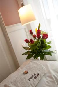 Želiezovce伊甸园宾馆的床上一束玫瑰花,带毛巾