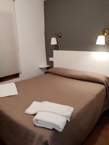 塞特卡萨斯Apartaments Can Bundanci的一间卧室配有一张带两条白色毛巾的床