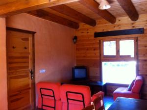 GuasoLa Cicuarala的客厅配有红色椅子和电视